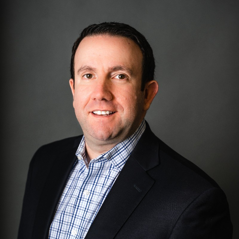 Cory Jorbin, Chief Compliance Officer for HUB International seen in blue and white checks shirt and black color suit